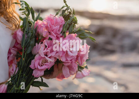 Frau Hände halten Bouquet von rosa eustoma Stockfoto