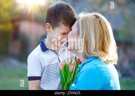 Kleiner Junge Mutter mit Tulpen am Muttertag überraschen Stockfoto