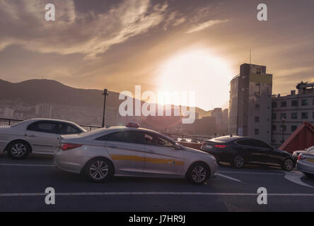 Blick auf den Sonnenuntergang auf Yeongdodaegyo Brücke mit Stau und Busan Stadtbild Stockfoto