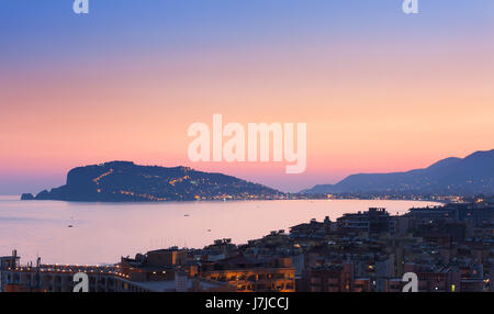 Stadtbild von Alanya bei Sonnenuntergang, Türkei. Im Hintergrund Halbinsel Alanya Stockfoto