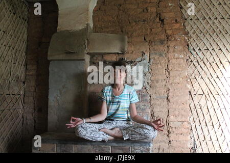 schöne flexable Frau machte Yoga-Posen auf Herd in Retro-alte Heimat Stockfoto