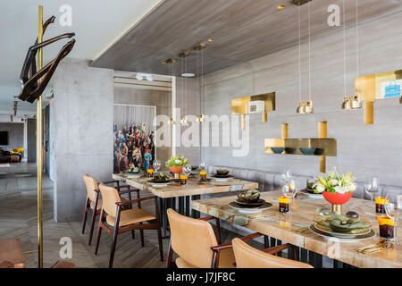 Laura Meroni Messing Hängelampen über maßgeschneiderte Stonewood Marmor Esstische mit fotografischen Arbeiten von Alex Prager Stockfoto