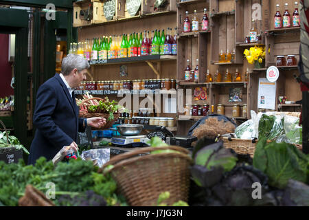 LONDON, UK - 22. April 2017: Ein unbekannter Mann kauft Obst und Gemüse in einem Stall in Borough Market in London am 22 März 201 Stockfoto