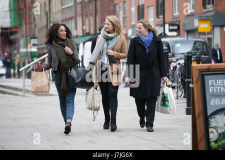 LONDON, ENGLAND - 12. März 2017 gehen drei Frauen mit Taschen auf der Straße diskutieren Stockfoto
