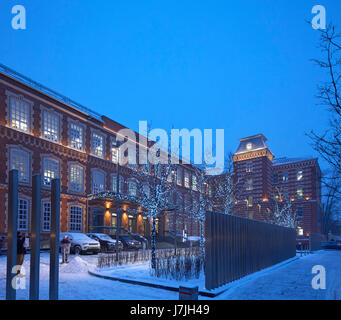 Frontale Außenansicht in der Abenddämmerung. Die bolschewistische Fabrik, Moskau, Russland. Architekt: John Mcaslan und Partner, 2016. Stockfoto