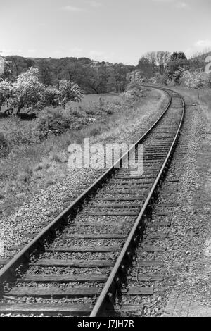 Eine eingleisig ländlichen normalspurigen Bahnstrecke auf einer Kurve in schwarz / weiß Stockfoto