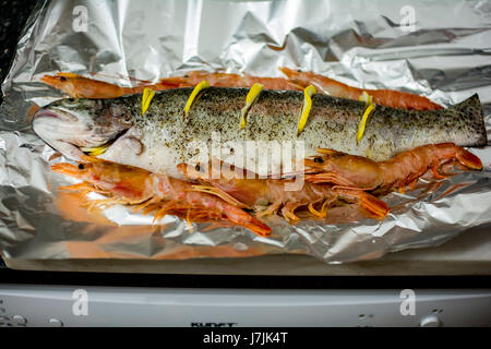 Fisch bereit, zusammen mit Olivenöl, Zitrone, Zwiebel, Knoblauch geröstet bekommen Stockfoto