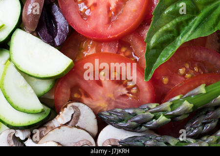 Vielzahl von frischen Zutaten wie Tomaten, Zucchini, Champignons, Oliven und Basilikum Stockfoto