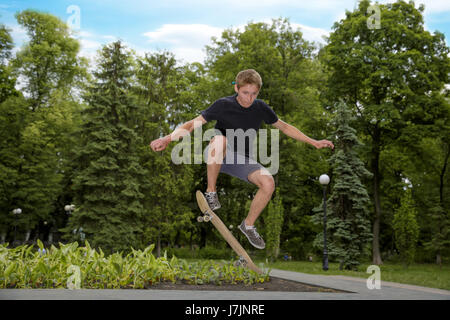 Nahaufnahme von ein Skateboarder Füße beim skating aktiv Leistung Stunt Teenagers Schuss in die Luft auf einem Skateboard Skate-Park Stockfoto