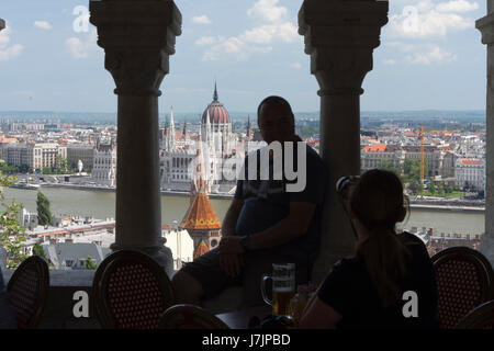 Ungarn, Budapest. Parlamentsgebäude, gesehen von einem Restaurant am Fishermans Bastion.Woman Mann Fotografieren Stockfoto