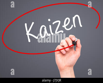 Hand des Mannes Kaizen mit schwarzem Filzstift auf Bildschirm zu schreiben. Isoliert auf grau. Wirtschaft, Technologie, Internet-Konzept. Stock Foto Stockfoto