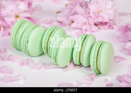 Traditionelle französische Macarons mit Zweigen von sakura Stockfoto