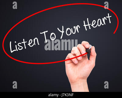 Hand des Mannes hören To Your Heart mit schwarzem Filzstift auf Bildschirm zu schreiben. Isoliert auf schwarz. Wirtschaft, Technologie, Internet-Konzept. Stock Foto Stockfoto