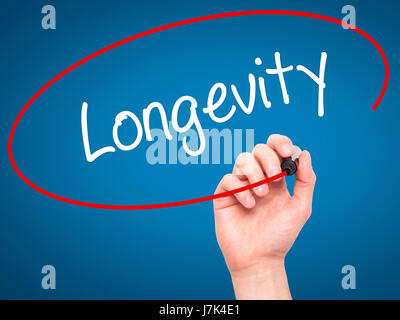 Hand des Mannes Langlebigkeit mit schwarzem Filzstift auf Bildschirm zu schreiben. Isoliert auf blau. Wirtschaft, Technologie, Internet-Konzept. Stock Foto Stockfoto