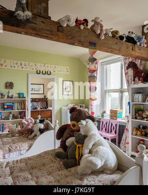 Florale Steppdecken auf Kinder zwei Einzelbetten im Schlafzimmer voller Plüschtiere Stockfoto