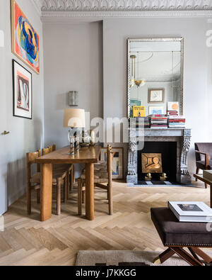 Holztisch und Stühle von Charlotte Perriand mit 1940er Jahre Spiegel über französische graue Marmor-Kamin Stockfoto