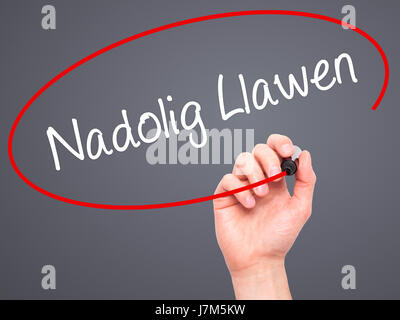 Hand des Mannes Nadolig Llawen (Frohe Weihnachten auf Walisisch) mit schwarzem Filzstift auf Bildschirm zu schreiben. Auf Hintergrund isoliert. Wirtschaft, Technik, internet Stockfoto