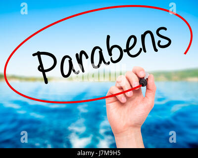 Hand des Mannes Parabene (Happy Birthday in portugiesischer Sprache) mit schwarzem Filzstift auf Bildschirm zu schreiben. Auf Hintergrund isoliert. Wirtschaft, Technologie, Internet co Stockfoto