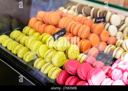 Bunte Macarons Dessert mit einem Schilder mit der Aufschrift: Orange und Vanille. Stockfoto