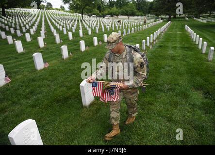 Arlington, USA. 25. Mai 2017. Ein Soldat aus der 3. US-Infanterie-Regiment setzt Fahnen an Grabstätten während der "Flaggen-In"-Zeremonie auf dem Arlington National Cemetery in Arlington, Virginia, USA, am 25. Mai 2017. Mehr als 1.000 Soldaten platziert Flaggen für über 284.000 Gräber auf dem Friedhof vor Memorial Day, dem letzten Montag im Mai. Bildnachweis: Yin Bogu/Xinhua/Alamy Live-Nachrichten Stockfoto