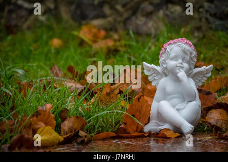 Kleine Engelsfigur neben einem Kind Grab im Friedhof Stockfoto