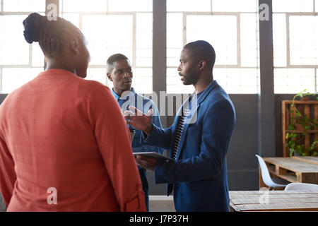 Drei afrikanische Kollegen sprechen Unternehmen zusammen in einem Büro Stockfoto