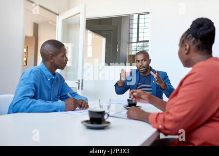 Afrikanische Unternehmer im Gespräch mit Kollegen in einem modernen Büro Stockfoto