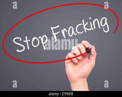 Hand des Mannes stoppen Fracking mit schwarzem Filzstift auf Bildschirm zu schreiben. Auf Hintergrund isoliert. Wirtschaft, Technologie, Internet-Konzept. Stock Foto Stockfoto