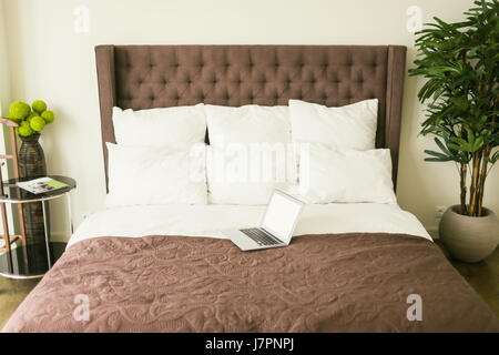 Bett mit Kissen mit Nachttisch im Schlafzimmer Stockfoto