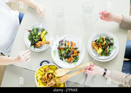 Draufsicht der beiden jungen Frauen Essen grüne Salate mit Chiken und Kartoffel Stockfoto
