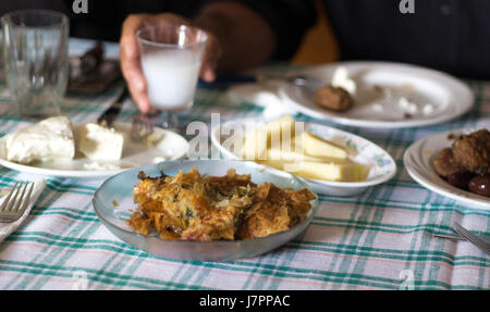 Ein griechisches Mittagessen zu Hause mit Feta, Ouzo und spinatkuchen auf einem Tisch mit Tischdecke, selektiven Fokus. Stockfoto