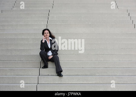 Business-Frau im schwarzen Anzug auf der Treppe Stockfoto