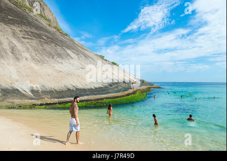 RIO DE JANEIRO - 4. März 2017: Beachgoers nutzen ein sonniges Wochenende in Itacoatiara Beach, ein Stadtteil in Niteroi. Stockfoto