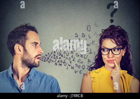 Sprache-Barriere-Konzept. Gutaussehenden Mann im Gespräch mit einer attraktiven jungen Frau mit Fragezeichen Stockfoto