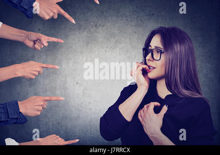 Ängstliche Frau von verschiedenen Leuten beurteilt. Konzept der Anklage schuldig Mädchens. Negative Emotionen fühlen Stockfoto