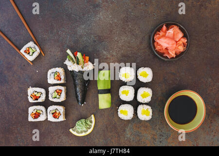 Vegetarische Sushi mit Sojasauce, Wasabi und eingelegtem Ingwer, serviert auf Stein Hintergrund. Ansicht von oben, Leerzeichen Stockfoto