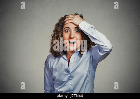 Überraschung erstaunt Frau. Closeup Portrait Frau, die in voller Unglauben weit geöffneten Mund isoliert graue Wand Hintergrund überrascht. Positive menschliche em Stockfoto