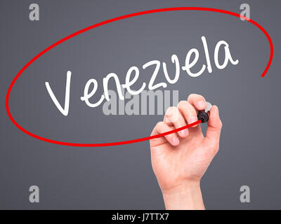 Hand des Mannes Venezuela mit schwarzem Filzstift auf Bildschirm zu schreiben. Isoliert auf grau. Wirtschaft, Technologie, Internet-Konzept. Stockfoto