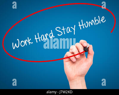 Mann Handschrift Arbeit hart bleiben bescheiden mit schwarzen Balken am Bildschirm. Isoliert auf blau. Wirtschaft, Technologie, Internet-Konzept. Stockfoto