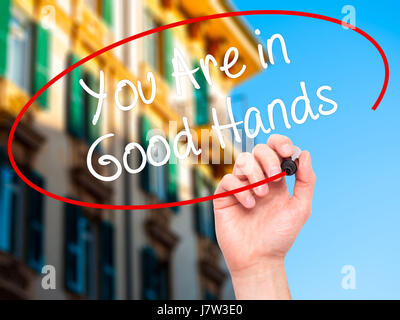 Hand des Mannes zu schreiben sind Sie in guten Händen mit schwarzem Filzstift auf Bildschirm. Isoliert auf Stadt. Wirtschaft, Technologie, Internet-Konzept. Stock Foto Stockfoto