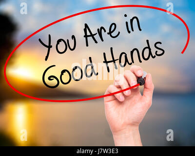 Hand des Mannes zu schreiben sind Sie in guten Händen mit schwarzem Filzstift auf Bildschirm. Isoliert auf Natur. Wirtschaft, Technologie, Internet-Konzept. Stock Foto Stockfoto