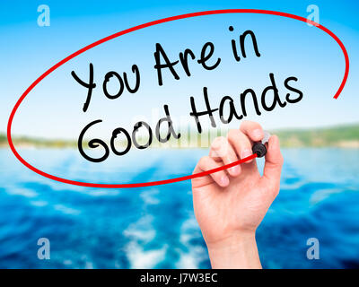 Hand des Mannes zu schreiben sind Sie in guten Händen mit schwarzem Filzstift auf Bildschirm. Isoliert auf Natur. Wirtschaft, Technologie, Internet-Konzept. Stock Foto Stockfoto