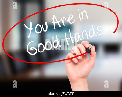 Hand des Mannes zu schreiben sind Sie in guten Händen mit schwarzem Filzstift auf Bildschirm. Isoliert auf Büro. Wirtschaft, Technologie, Internet-Konzept. Stock Foto Stockfoto