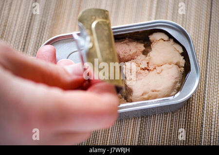 Frau Finger öffnen Blechdose mit Lebertran. Stockfoto