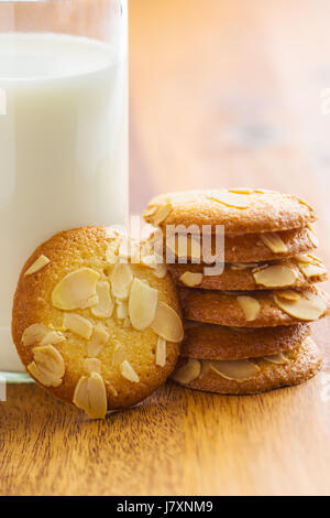 Süße Mandel Kekse mit Milch auf Holztisch. Stockfoto