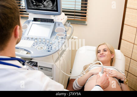 Schwangere Frau beim Arzt. Ultraschall-Diagnostik-Maschine. Ultraschall Frau schwanger Arzt Schwangerschaftsvorsorge Klinik medizinisches Konzept Stockfoto
