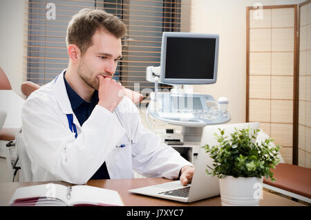 Arzt Gynäkologe im Büro arbeiten. Ultraschall im Hintergrund Stockfoto