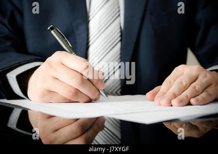 Geschäftsmann unterschreibt einen Vertrag. Mann Vertragsunterzeichnung Handschrift Stift schreiben Papier Konzept Stockfoto