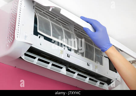 Klimaanlage reinigen. Mann in Handschuhen prüft den Filter. Stockfoto