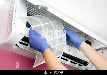 Klimaanlage reinigen. Mann in Handschuhen prüft den Filter. Stockfoto